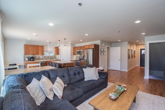 living area with recessed lighting, baseboards, and wood finished floors