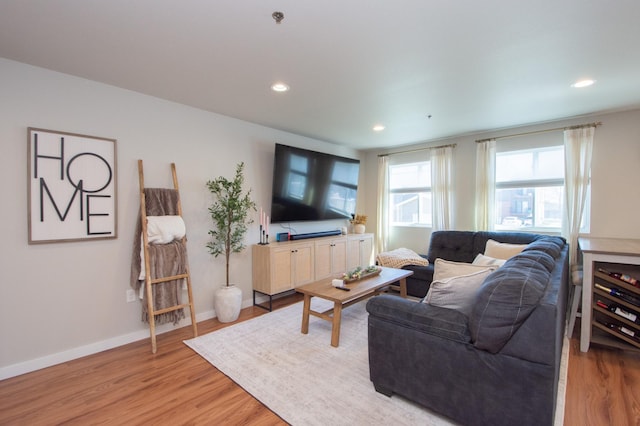 living area featuring recessed lighting, baseboards, and light wood finished floors