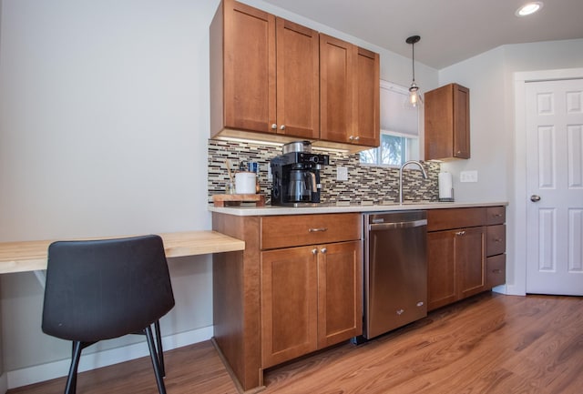 kitchen with a sink, light wood finished floors, dishwasher, and light countertops