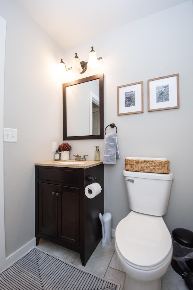 bathroom featuring toilet, baseboards, tile patterned floors, and vanity