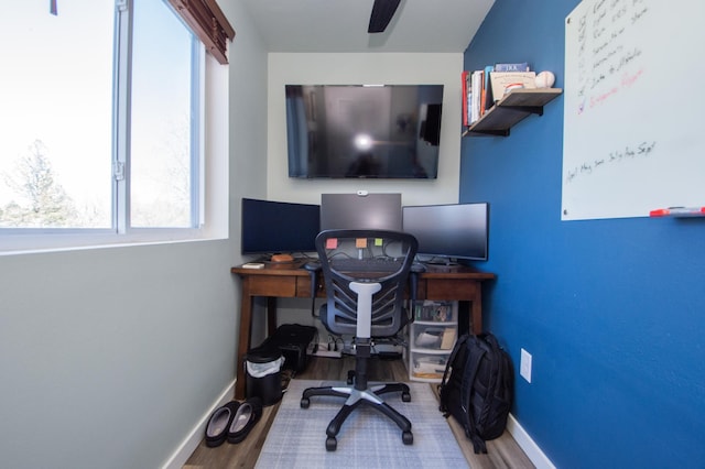 home office with a ceiling fan, baseboards, a wealth of natural light, and wood finished floors