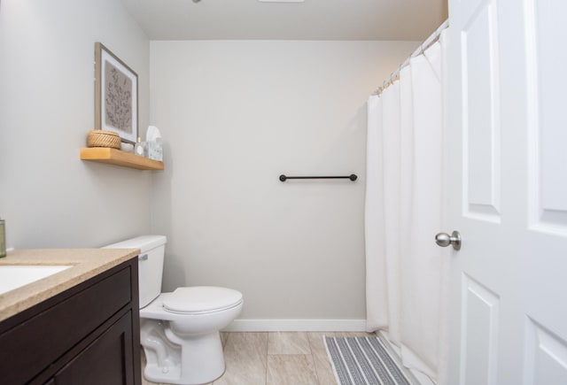 full bath with vanity, baseboards, and toilet
