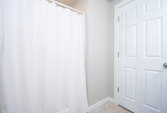 bathroom with baseboards, tile patterned flooring, and curtained shower