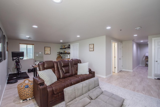 living area with recessed lighting, baseboards, and a bar