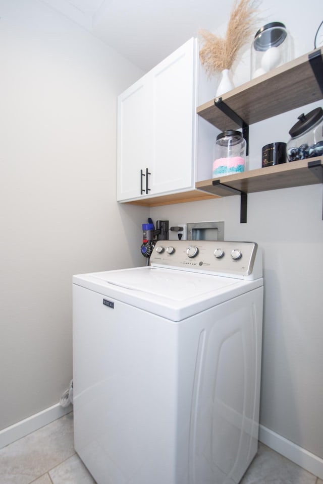 laundry room with washer / dryer, baseboards, light tile patterned floors, and cabinet space