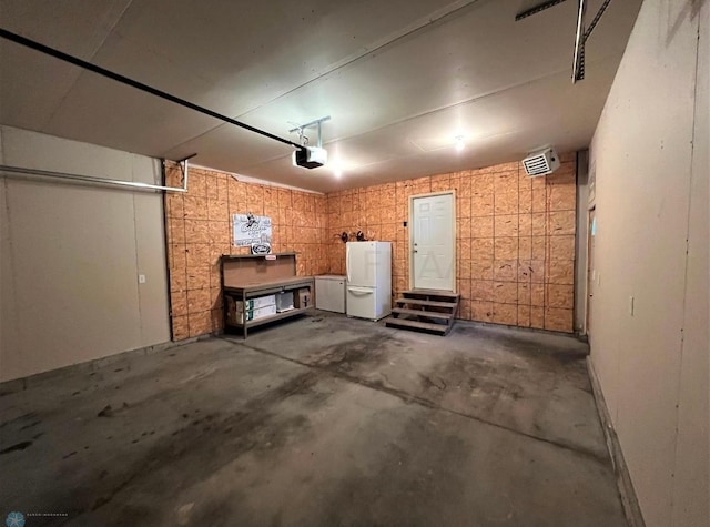 garage featuring freestanding refrigerator and a garage door opener