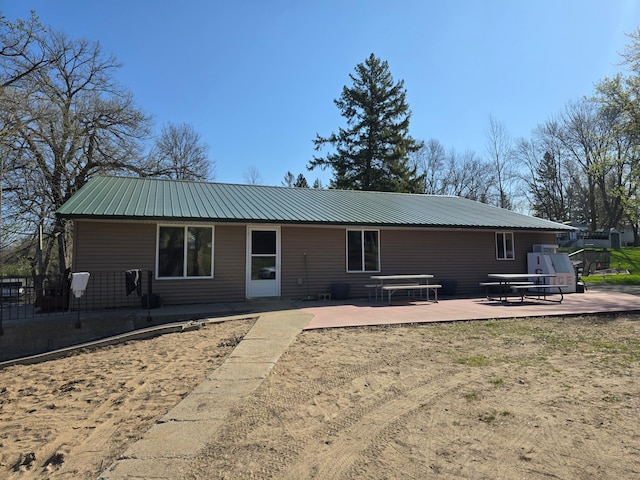 rear view of property with a patio area and metal roof