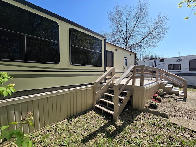 view of property exterior featuring stairway and a wooden deck