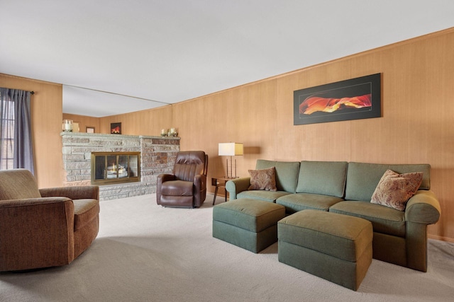 carpeted living room featuring wood walls and a fireplace