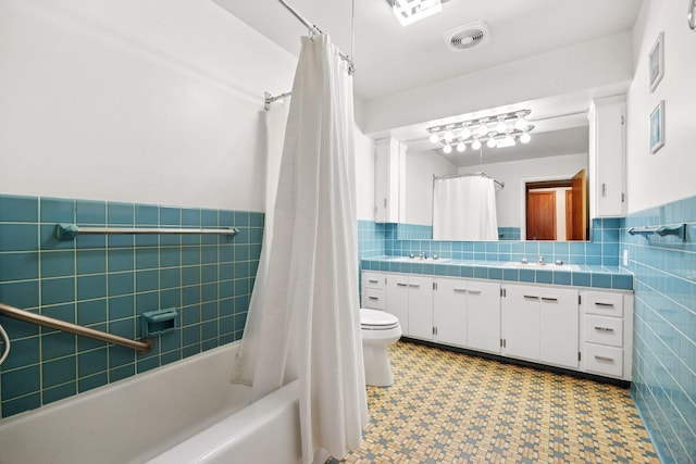 full bathroom featuring vanity, tile walls, wainscoting, and toilet