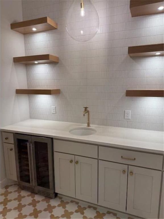 bathroom with tile patterned floors, wine cooler, vanity, and tile walls