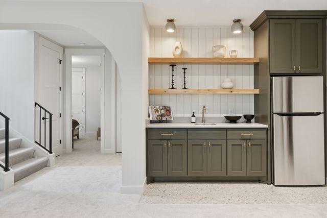 9399 Eagle Ridge Way, Chanhassen, MN 55317 - kitchen featuring freestanding refrigerator, arched walkways, open shelves, light carpet, and light countertops