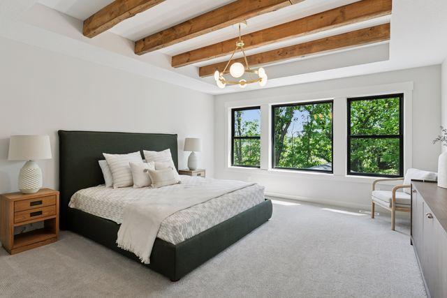 9399 Eagle Ridge Way, Chanhassen, MN 55317 - bedroom featuring multiple windows, beamed ceiling, light colored carpet, and a chandelier