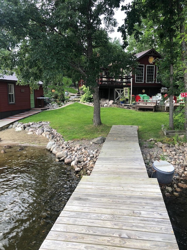 view of dock with a lawn and a deck with water view