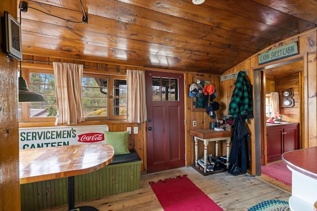 interior space featuring wooden walls, lofted ceiling, hardwood / wood-style floors, and wooden ceiling