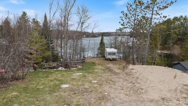 view of yard with a water view and driveway
