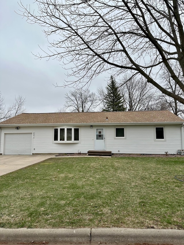 ranch-style house featuring an attached garage, driveway, and a front lawn