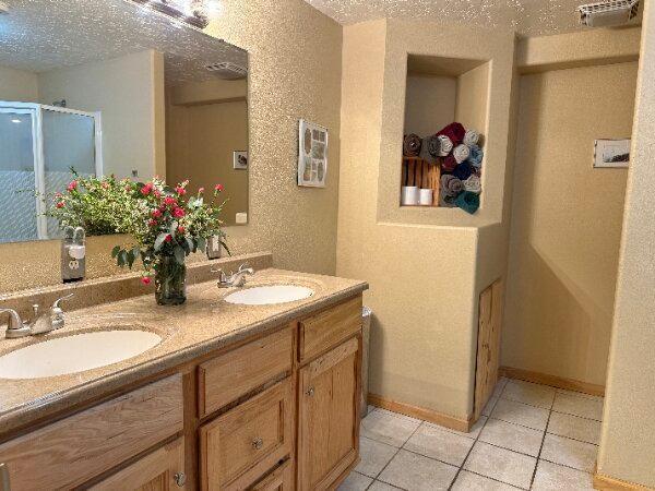 bathroom featuring a textured ceiling, a textured wall, and a sink