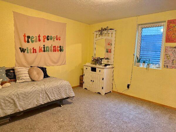 bedroom featuring light carpet and a textured ceiling