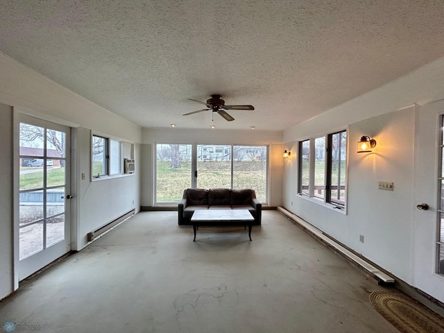 sunroom featuring a textured ceiling, baseboards, and a baseboard radiator
