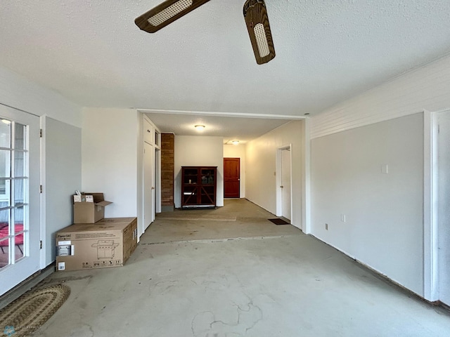 unfurnished living room with a textured ceiling and unfinished concrete flooring