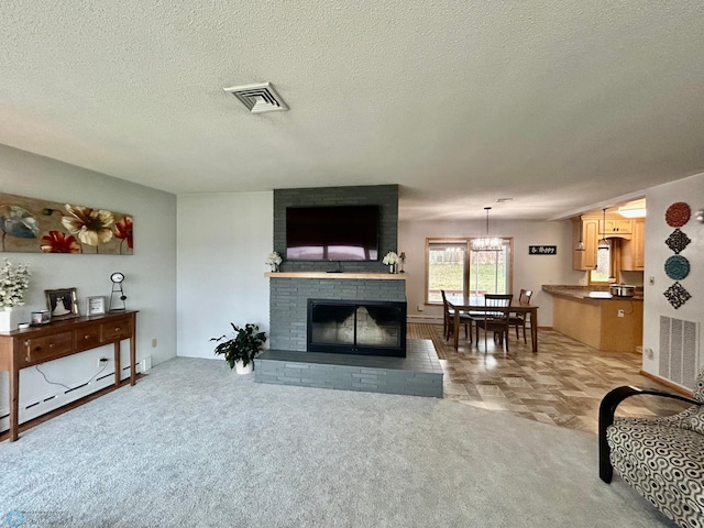 living room with a textured ceiling, light colored carpet, visible vents, a fireplace, and a baseboard radiator