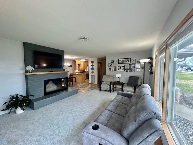 living room featuring a fireplace, light carpet, and visible vents
