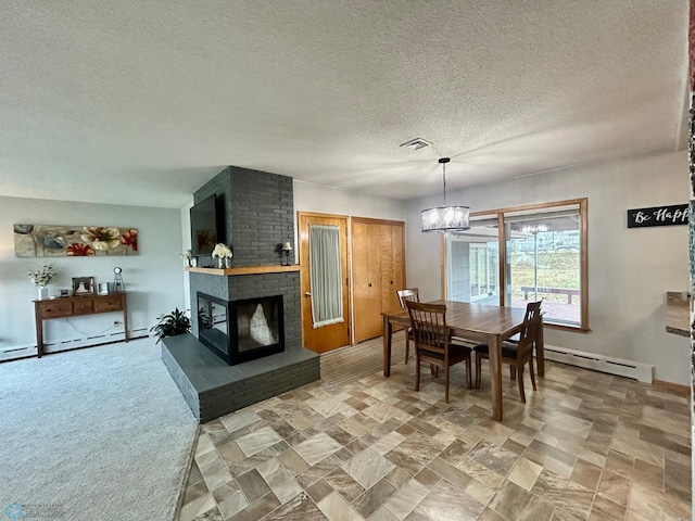 dining room with a brick fireplace, a chandelier, visible vents, and a baseboard radiator
