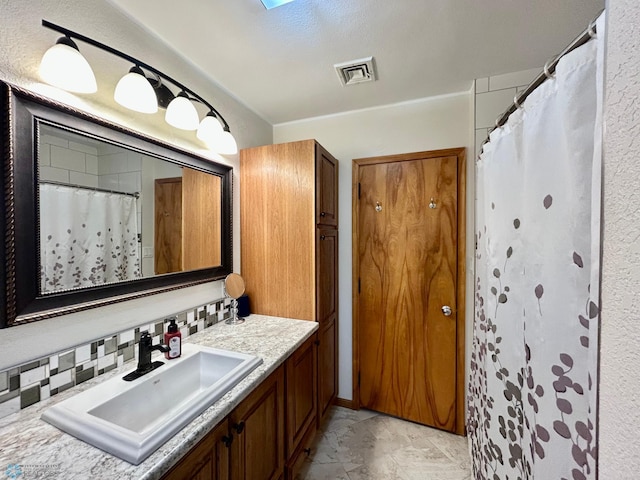full bath with a skylight, visible vents, curtained shower, and vanity