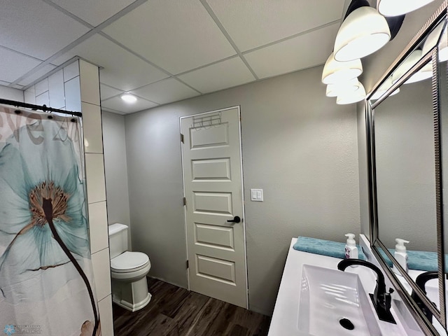 full bath with a paneled ceiling, toilet, a shower with shower curtain, and wood finished floors
