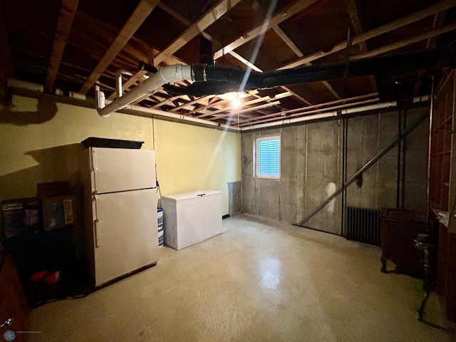basement featuring freestanding refrigerator and fridge