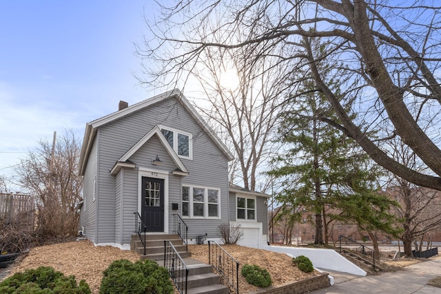 view of front of property featuring fence, driveway, a chimney, and a garage