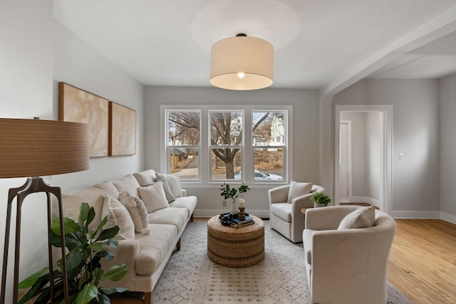 living area featuring baseboards and wood finished floors