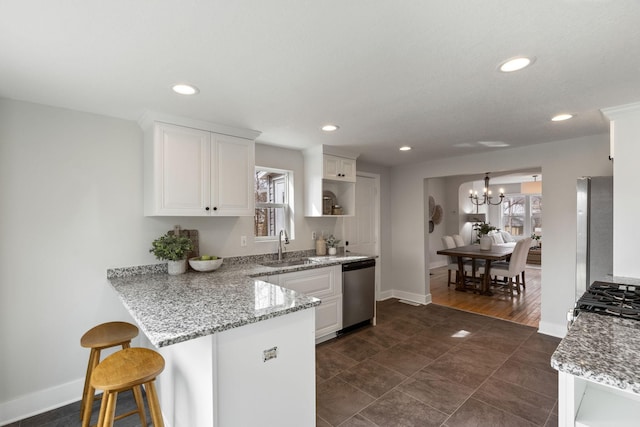 kitchen with a breakfast bar area, stainless steel dishwasher, baseboards, white cabinets, and an inviting chandelier
