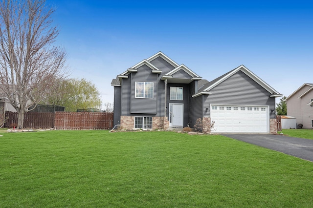 view of front of home with fence, aphalt driveway, a front lawn, and a garage