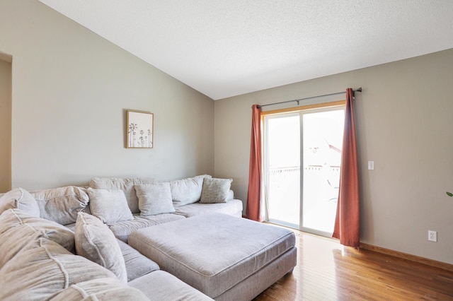living room with vaulted ceiling, light wood-style flooring, and baseboards