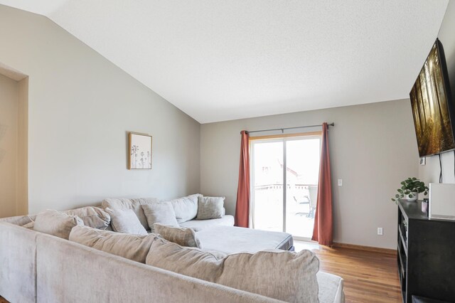 living area with light wood-style flooring, vaulted ceiling, and baseboards
