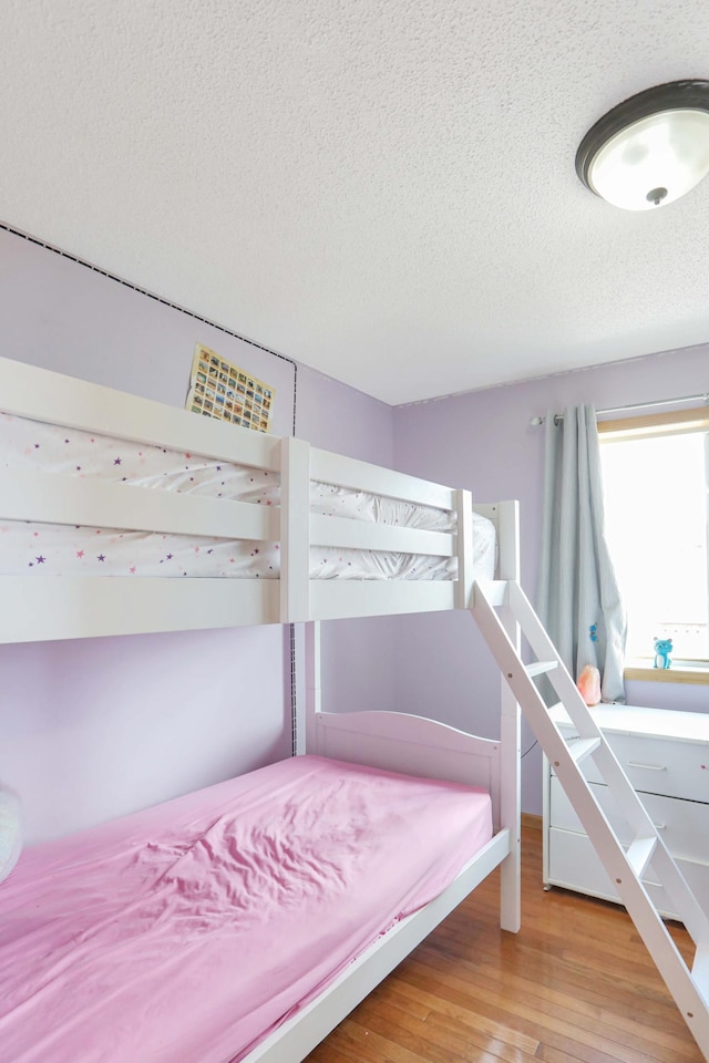 bedroom featuring light wood-style floors and a textured ceiling