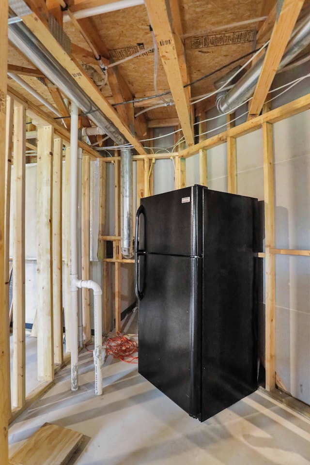 unfinished below grade area with freestanding refrigerator
