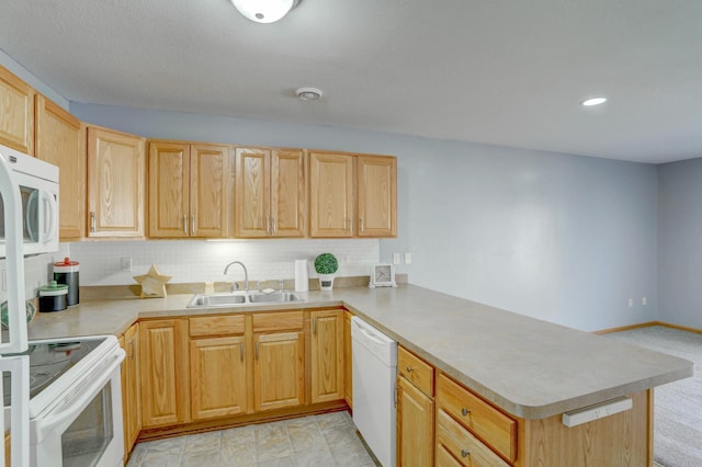 kitchen featuring a peninsula, light brown cabinetry, white appliances, light countertops, and a sink
