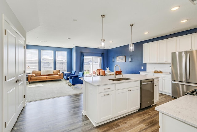 kitchen featuring decorative light fixtures, dark wood-style flooring, a sink, white cabinetry, and stainless steel appliances