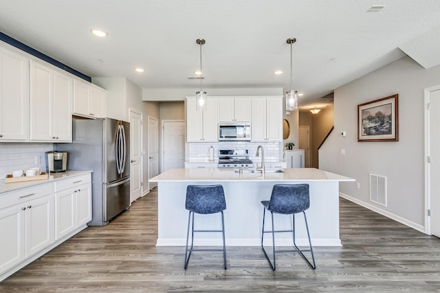 kitchen with visible vents, appliances with stainless steel finishes, a sink, and decorative backsplash