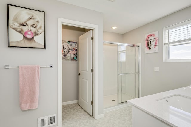 full bathroom featuring vanity, visible vents, tile patterned floors, a shower stall, and baseboards