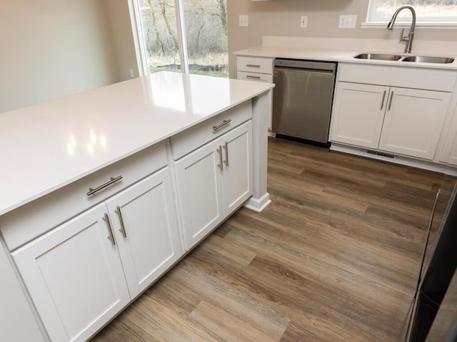 kitchen featuring white cabinets, dark wood-style flooring, a sink, and dishwasher