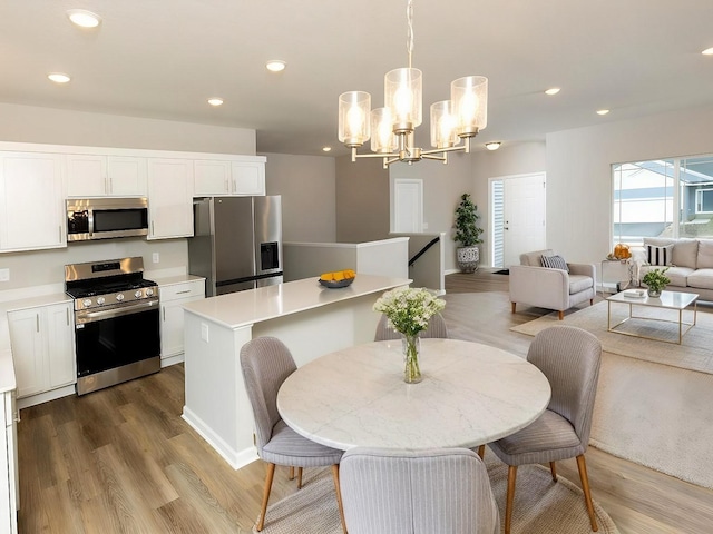 dining room featuring light wood-style floors, recessed lighting, and a notable chandelier