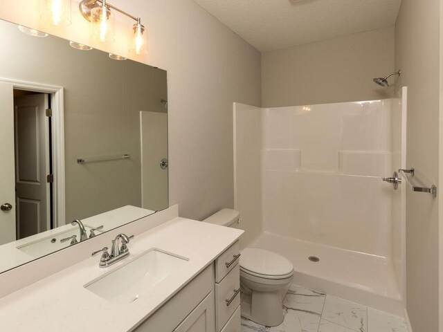 full bath featuring a textured ceiling, walk in shower, vanity, toilet, and marble finish floor