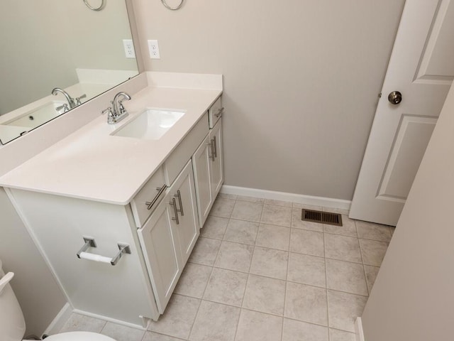 bathroom featuring visible vents, baseboards, vanity, tile patterned floors, and toilet