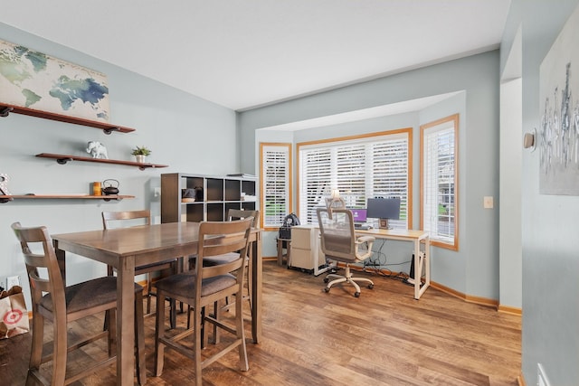 dining space featuring baseboards and light wood-style flooring
