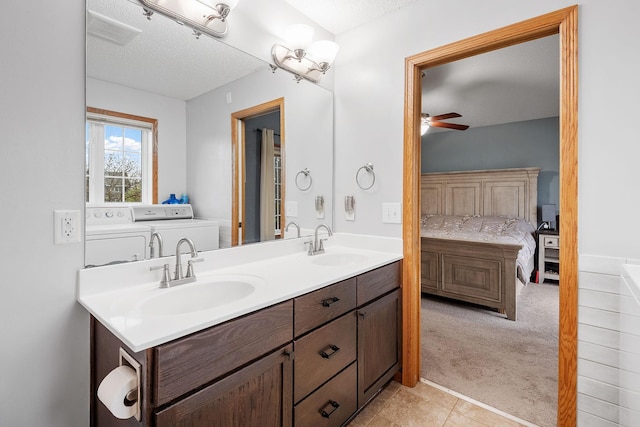 bathroom with a sink, a ceiling fan, independent washer and dryer, and connected bathroom