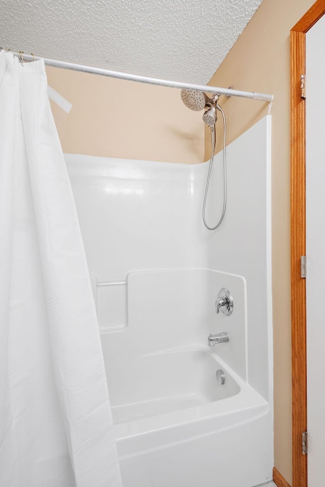 full bathroom featuring a textured ceiling and shower / bath combo